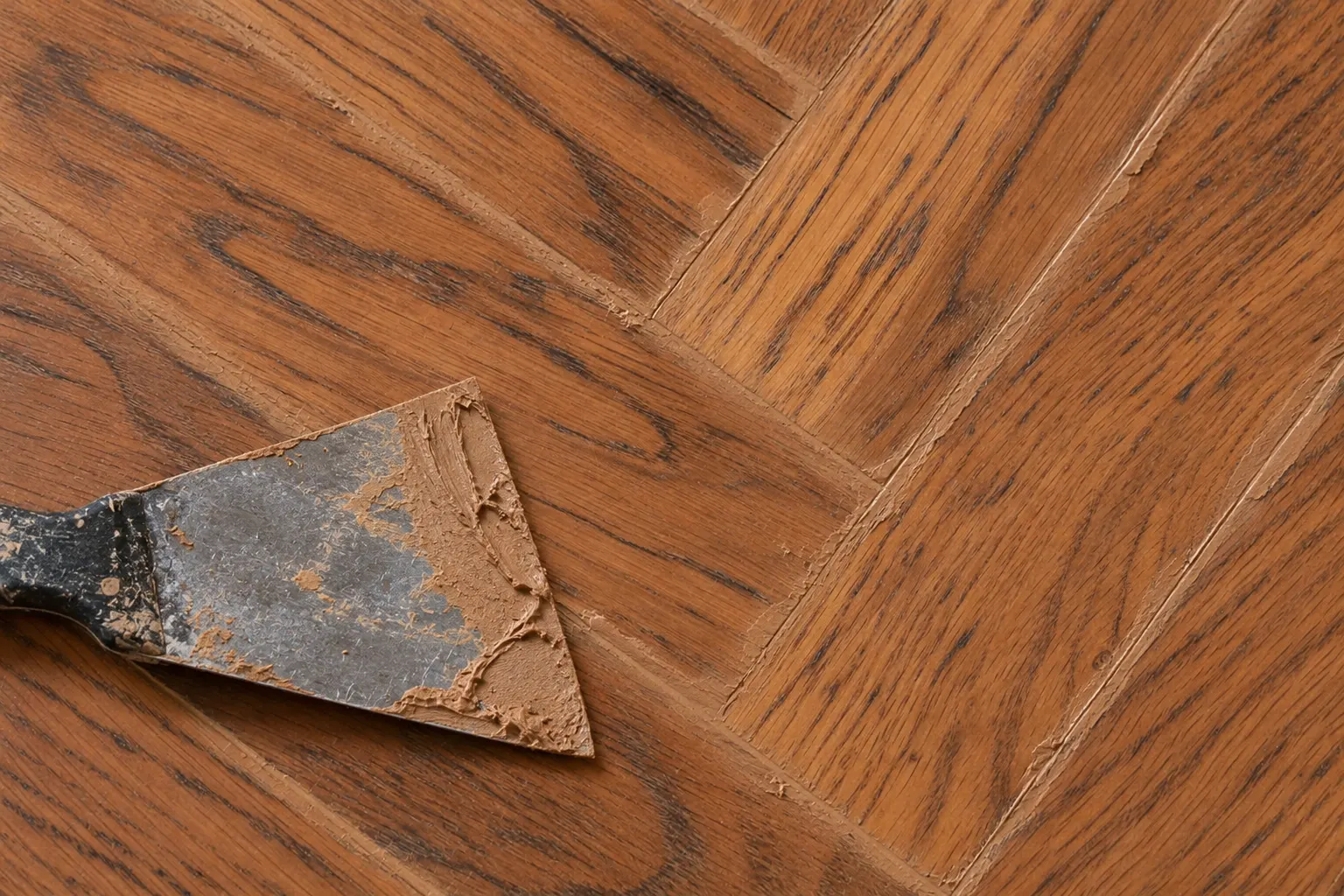 Juntas del parquet rellenas con masilla color madera